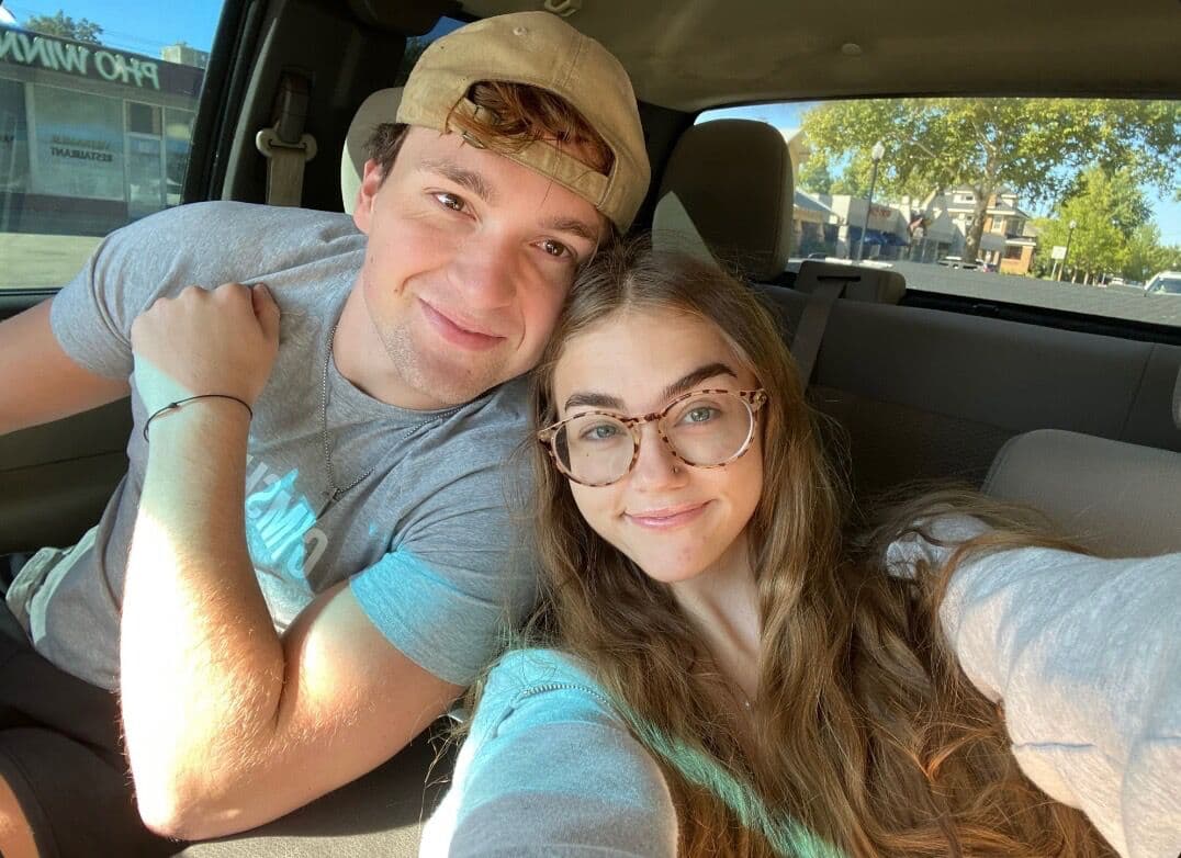 Elise and Tyler leaning together for a selfie in the car